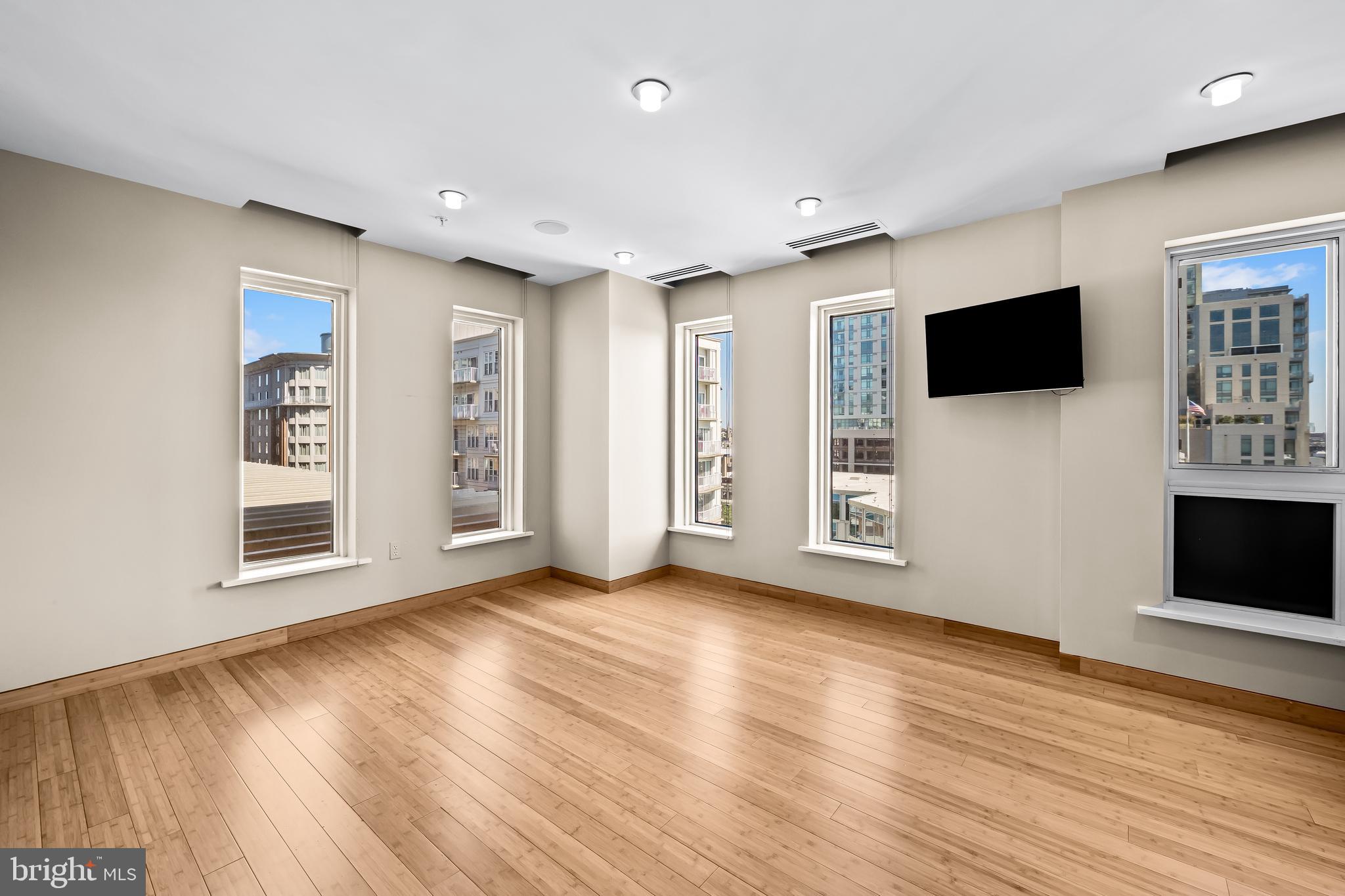 717 President Street, Unit PH802 Baltimore, MD 21202 - Photo 47 of 77 a view of a livingroom with wooden floor and a flat screen tv