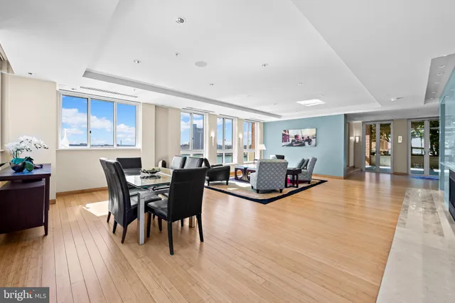 a open kitchen with stainless steel appliances kitchen island granite countertop a table chairs and a refrigerator