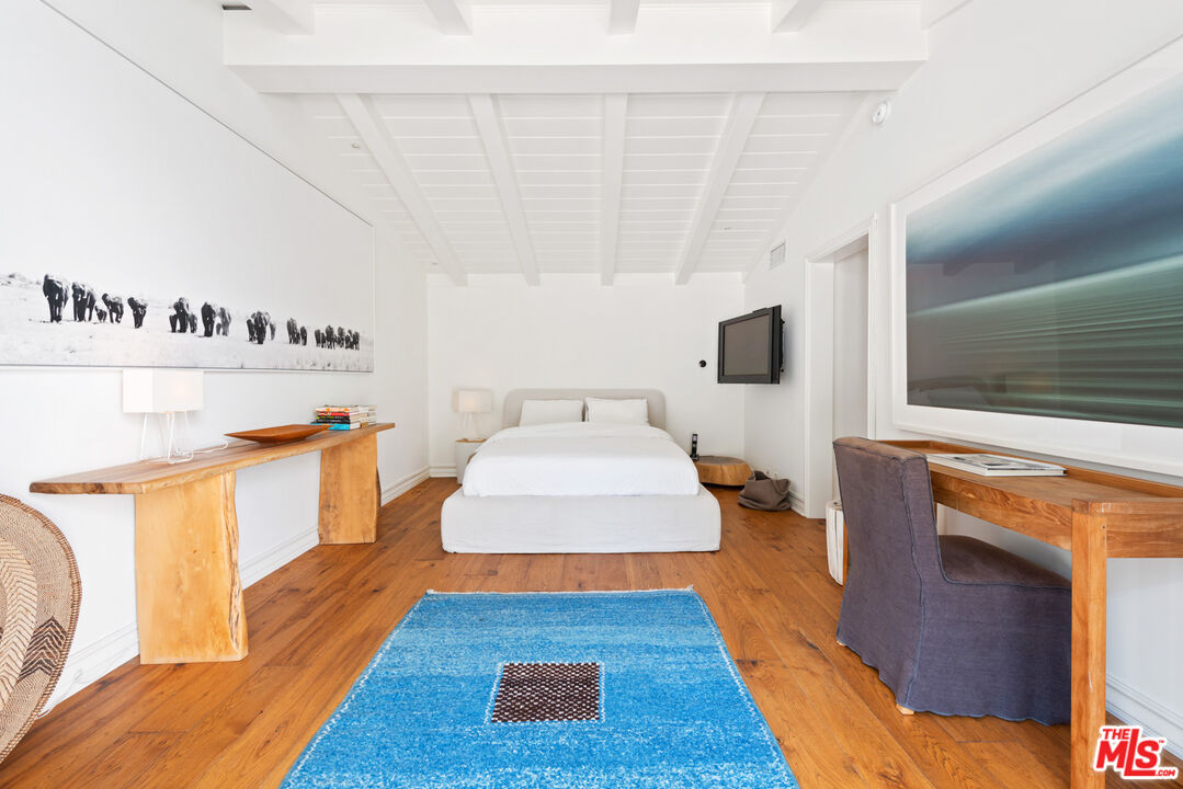 6238 Bonsall Drive Malibu, CA 90265 - Photo 22 of 40 a spacious bedroom with a bed and a flat screen tv