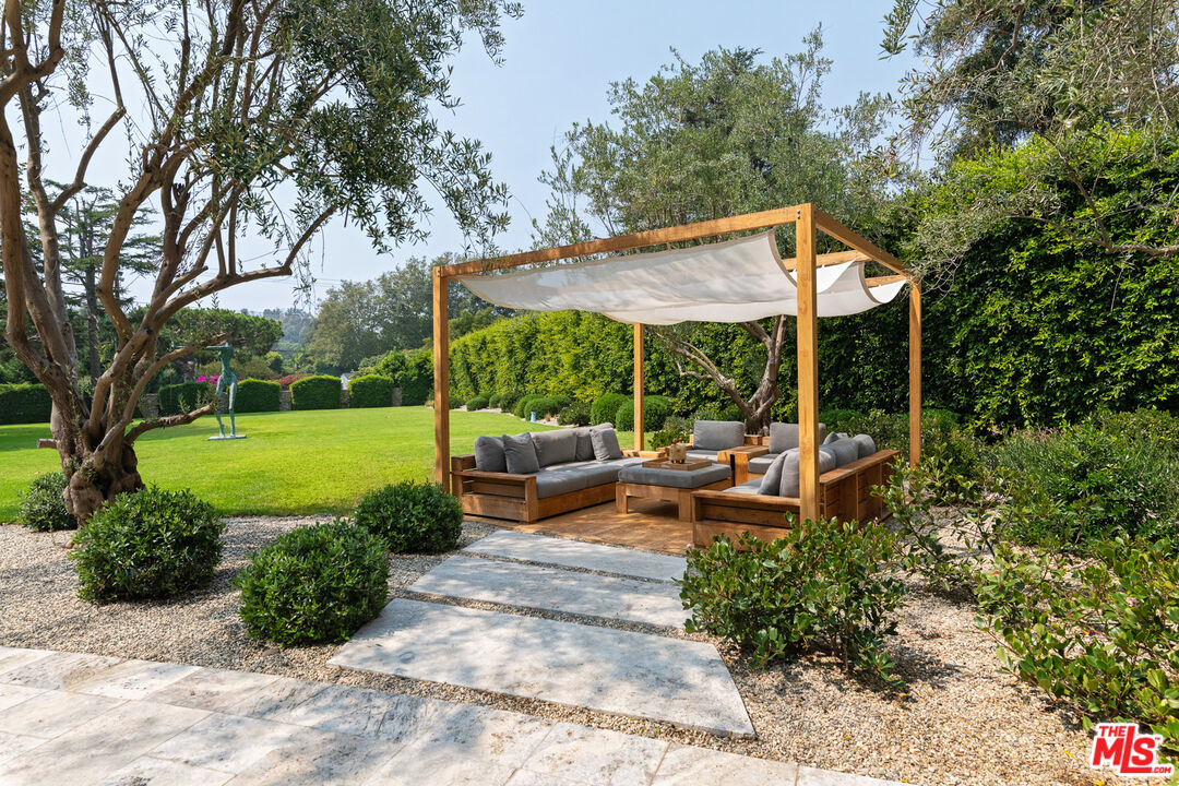 6238 Bonsall Drive Malibu, CA 90265 - Photo 3 of 40 a view of a patio with table and chairs potted plants and a large tree