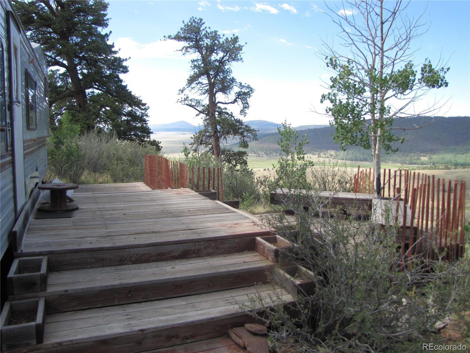 a view of backyard with wooden fence and trees
