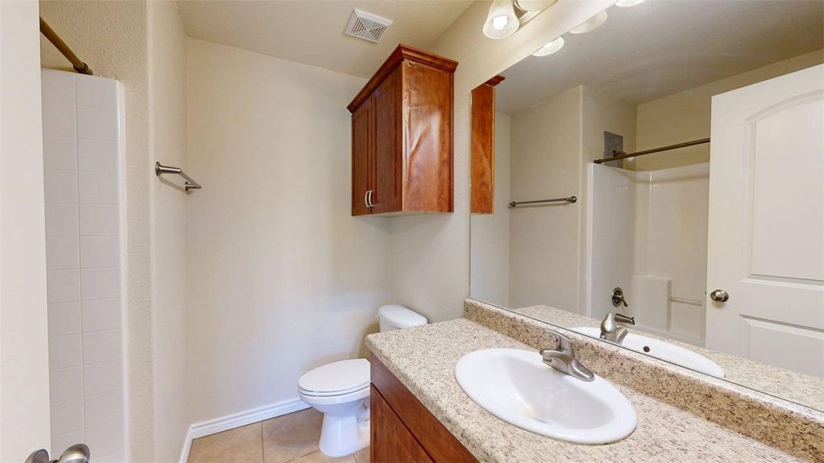 4436 Reveille Road College Station, TX 77845 - Photo 18 of 31 a bathroom with a granite countertop sink toilet and a mirror