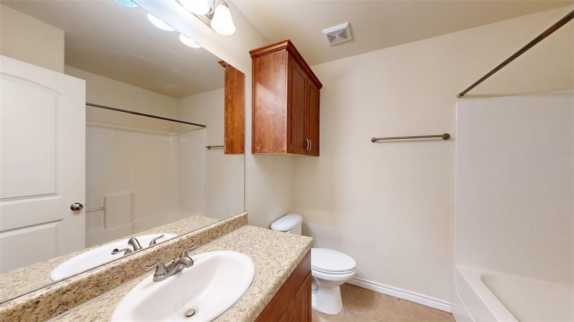 4436 Reveille Road College Station, TX 77845 - Photo 22 of 31 a bathroom with a granite countertop sink toilet and mirror