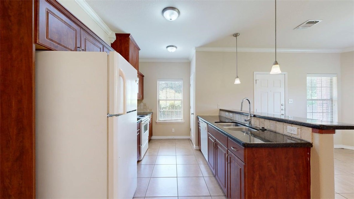 4436 Reveille Road College Station, TX 77845 - Photo 5 of 31 a kitchen with a sink refrigerator and cabinets