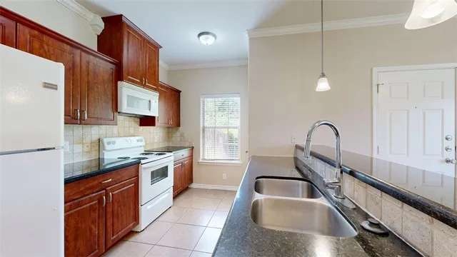 a kitchen with a sink refrigerator and cabinets