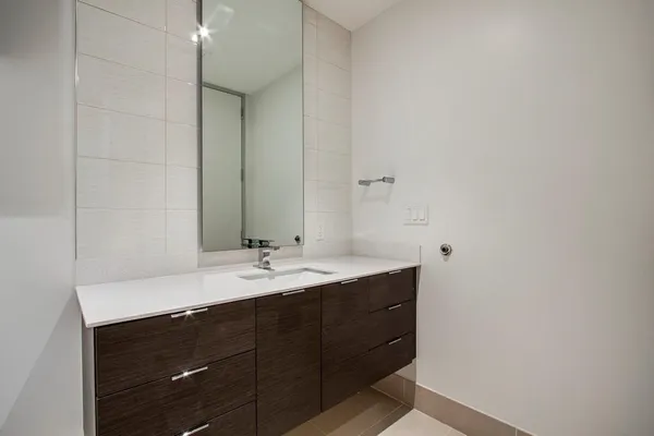 a bathroom with a granite countertop sink and a mirror