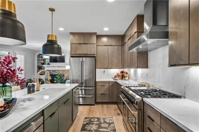 a kitchen with stainless steel appliances granite countertop a sink stove and wooden floor