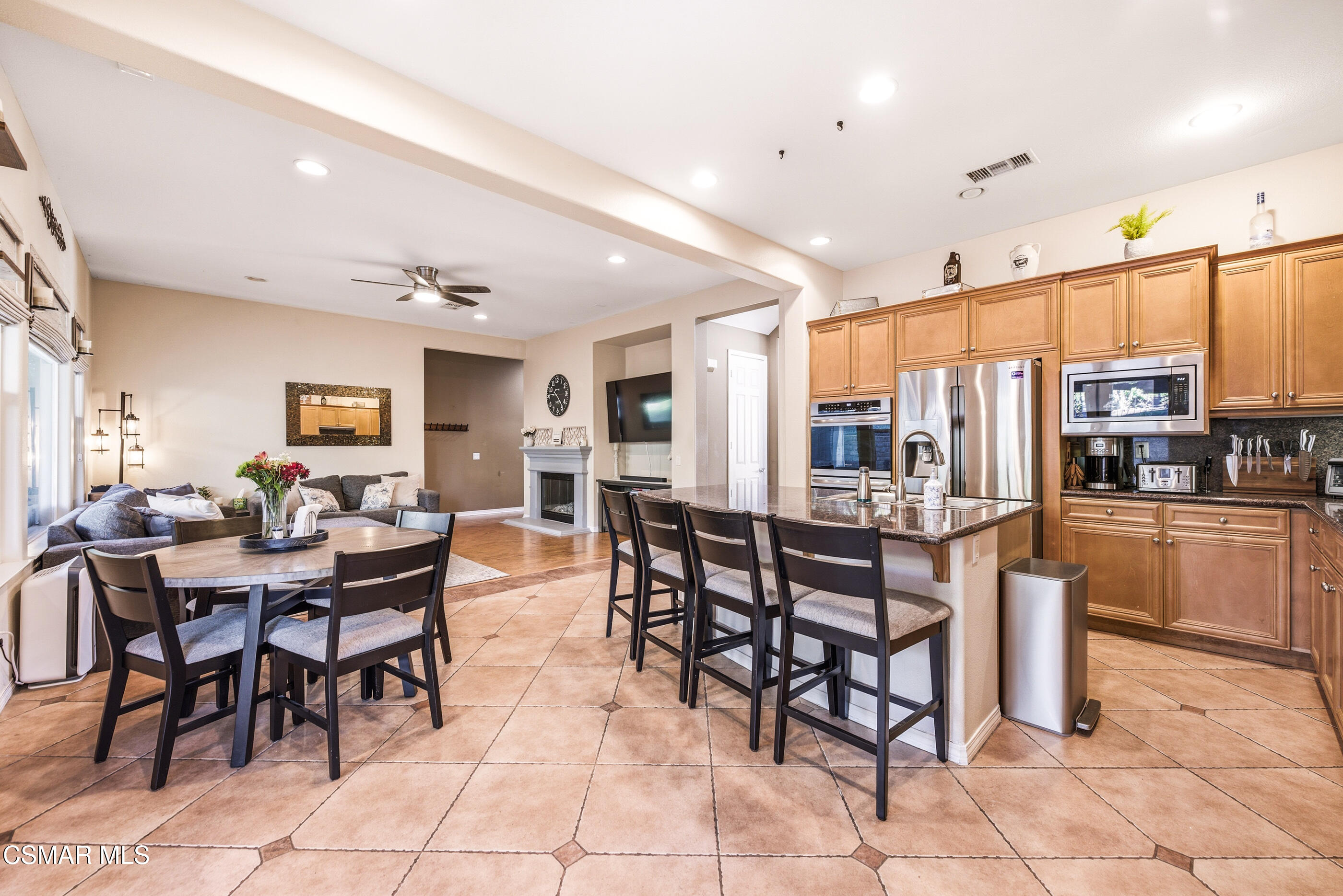4741 Westwood Street Simi Valley, CA 93063 - Photo 9 of 48 a dining hall with stainless steel appliances kitchen island granite countertop a dining table chairs and view kitchen