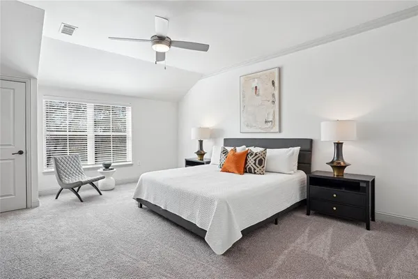a large bedroom with a bed and wooden floor