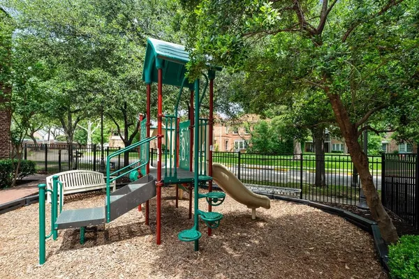 a view of a park with couches chair and wooden fence