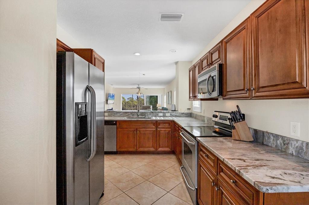 8413 Placida Road, Unit 308 Placida, FL 33946 - Photo 13 of 40 a kitchen with stainless steel appliances granite countertop a refrigerator stove and sink