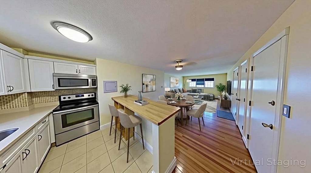 31 Arlington Road, Unit 6 Woburn, MA 01801 - Photo 3 of 26 a kitchen with stainless steel appliances granite countertop a stove refrigerator and a refrigerator