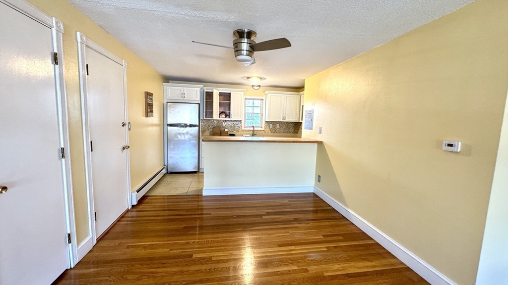 31 Arlington Road, Unit 6 Woburn, MA 01801 - Photo 8 of 26 a view of a kitchen with wooden floor and a ceiling fan