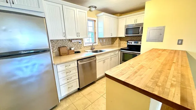 a kitchen with stainless steel appliances kitchen island granite countertop a sink stove and refrigerator