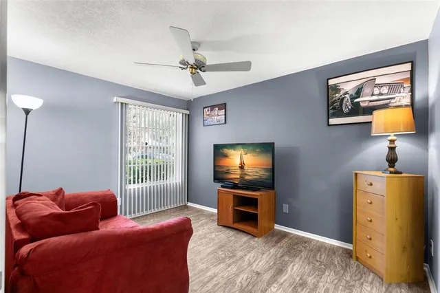 a living room with furniture and a ceiling fan