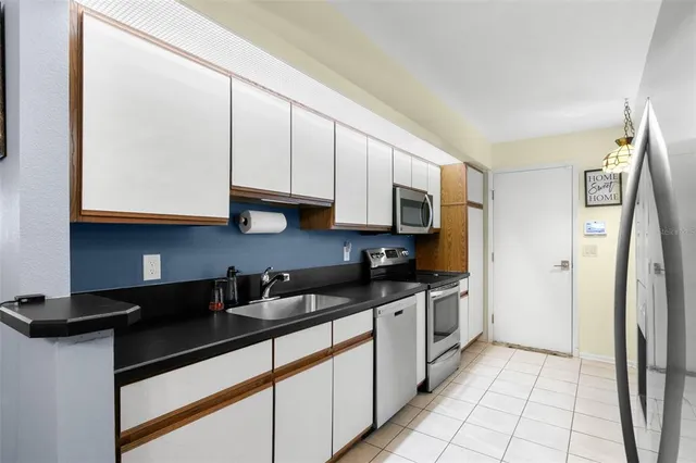 a kitchen with stainless steel appliances granite countertop a sink a stove and a refrigerator