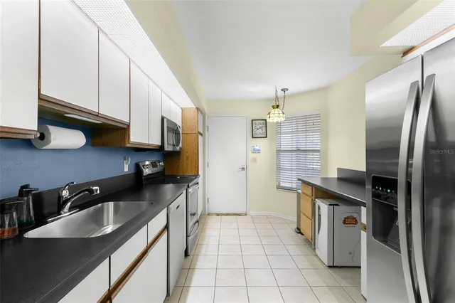 a kitchen with stainless steel appliances granite countertop a sink a stove and a refrigerator