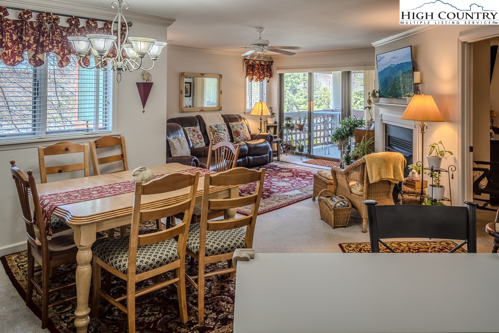 151 Deer Valley Drive, Unit 231 Boone, NC 28607 - Photo 13 of 35 a living room with furniture a chandelier and large windows