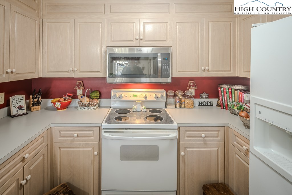 151 Deer Valley Drive, Unit 231 Boone, NC 28607 - Photo 17 of 35 a kitchen with a stove and white cabinets