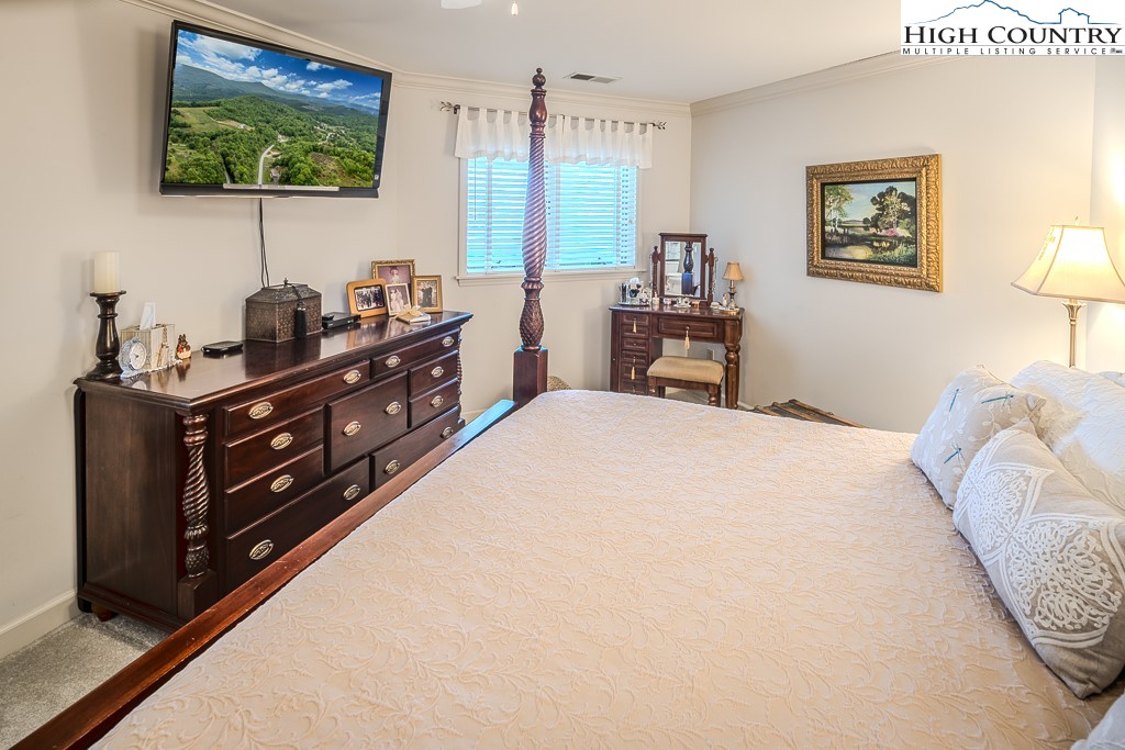 151 Deer Valley Drive, Unit 231 Boone, NC 28607 - Photo 21 of 35 a bedroom with a bed and a flat tv screen on dresser