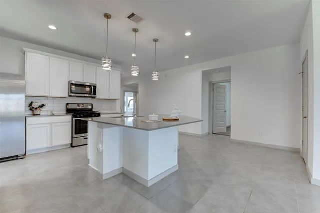 a kitchen with white cabinets and white appliances