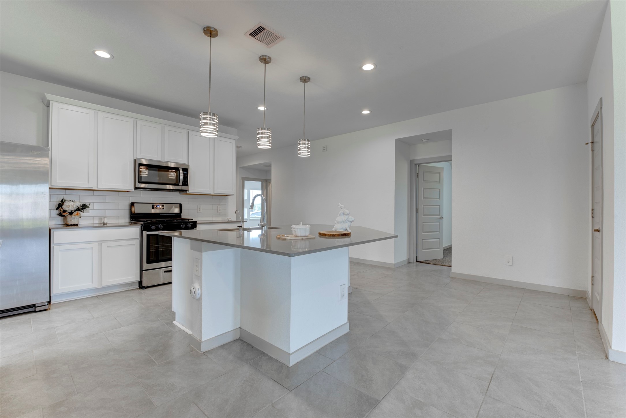 29751 Cayenne Circle Katy, TX 77494 - Photo 9 of 36 a kitchen with stainless steel appliances kitchen island a white cabinets and sink