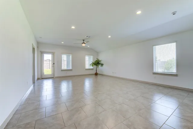an empty room with a window and a ceiling fan