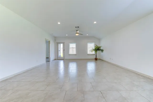 an empty room with windows and cabinet