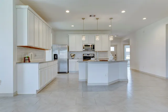 a large kitchen with cabinets and stainless steel appliances