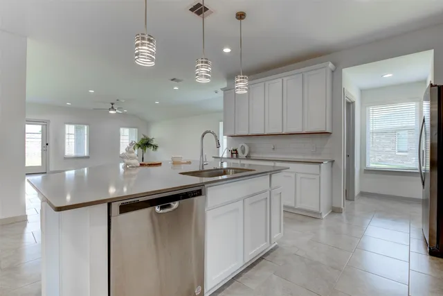 a large kitchen with stainless steel appliances kitchen island a large counter top and a stove top oven