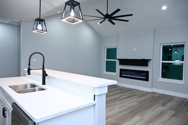 a kitchen with stainless steel appliances a white table chairs and a refrigerator