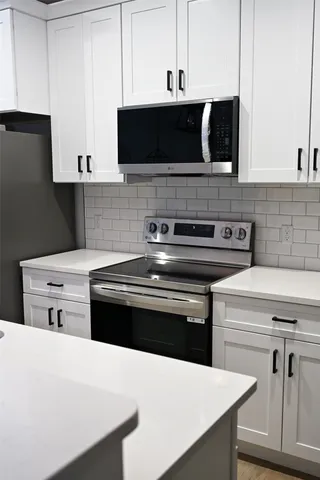 a kitchen with stainless steel appliances a stove microwave and cabinets