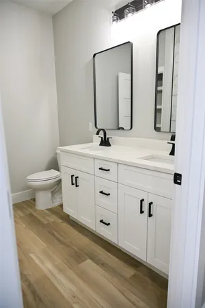 a bathroom with a double vanity sink toilet and mirror
