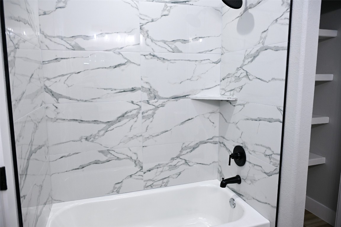 516 North Hackberry Avenue Luling, TX 78648 - Photo 8 of 36 Bathroom featuring a combined bath / shower with marble appearance