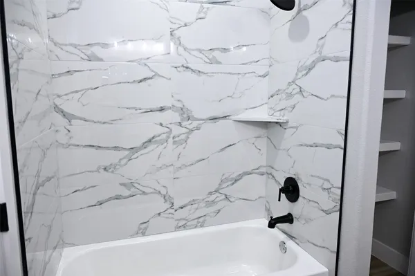 a bathroom with a bathtub and shower