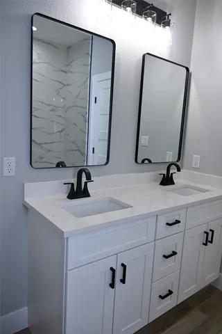 a bathroom with 2 sink and a mirror