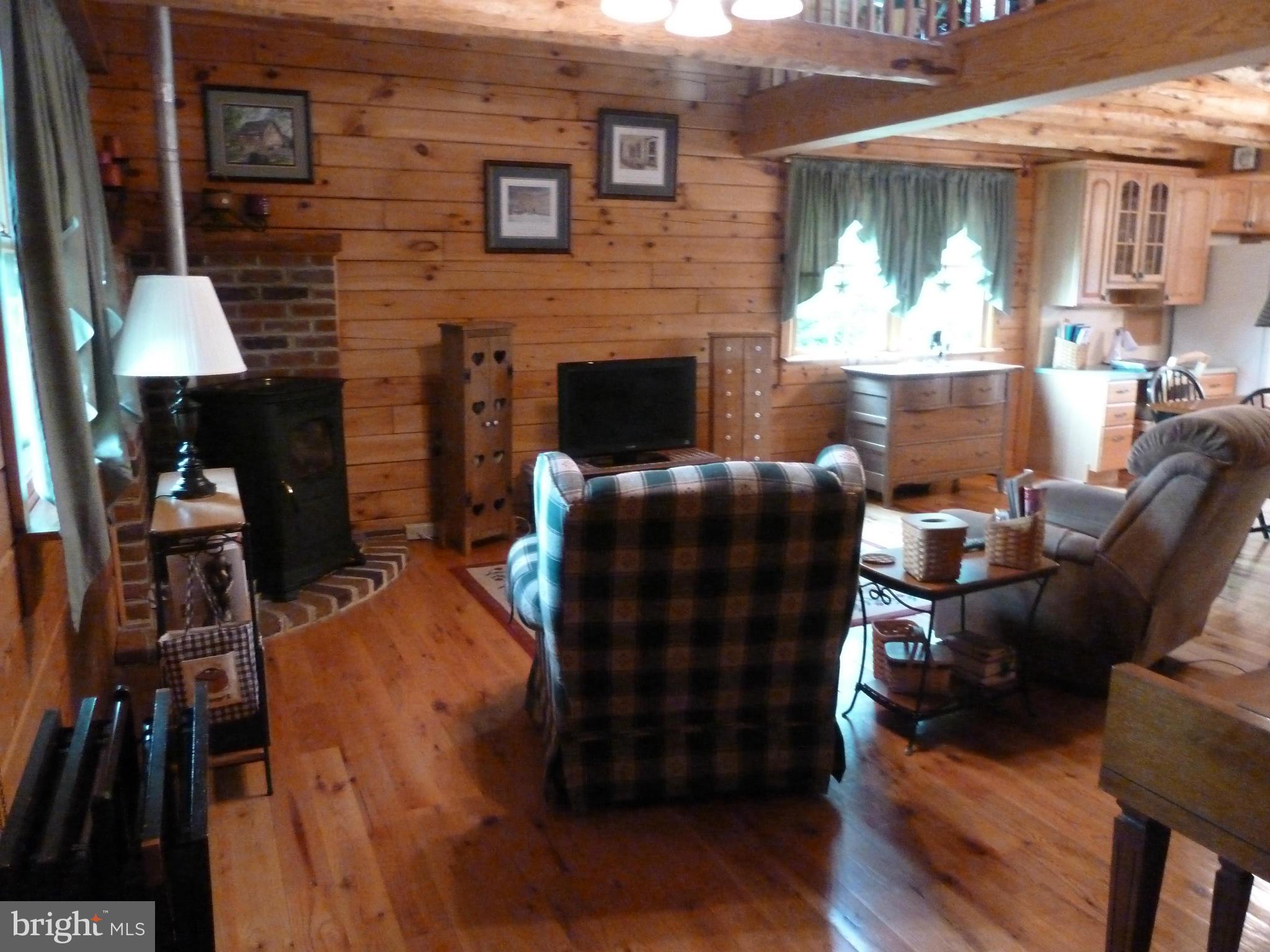 11682 Rocky Meadow Road Clear Spring, MD 21722 - Photo 8 of 30 a living room with furniture wooden floor and a fireplace