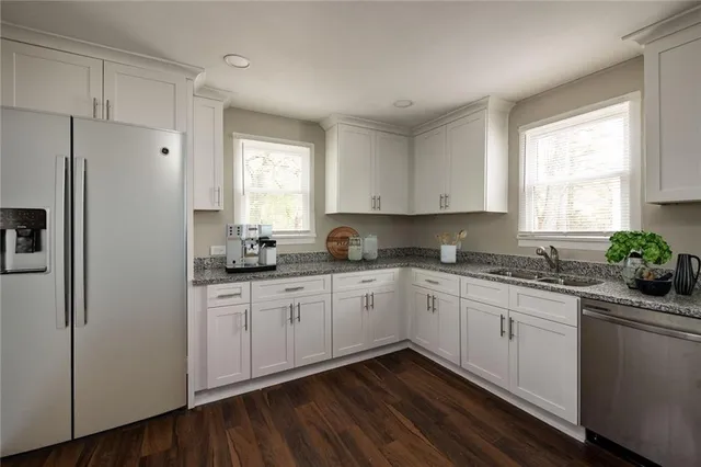 a kitchen with granite countertop cabinets stainless steel appliances a sink and window