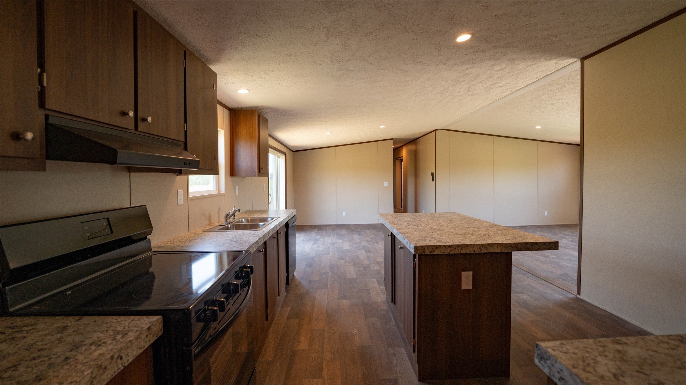 1121 Callihan Road Luling, TX 78648 - Photo 25 of 35 a kitchen with granite countertop a stove a sink and dishwasher with wooden floor