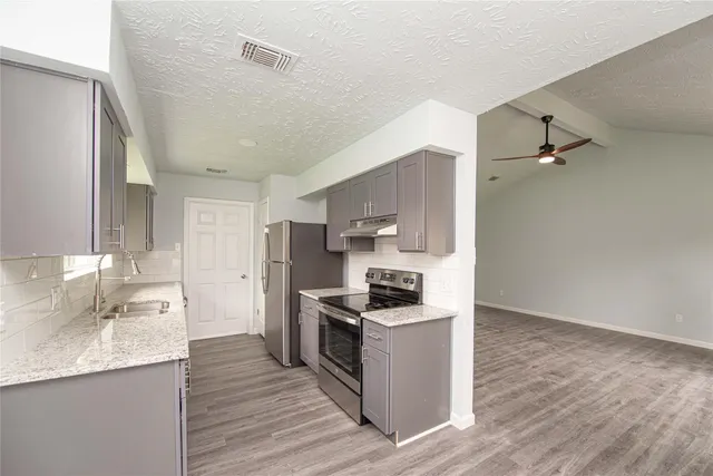 a kitchen with stainless steel appliances granite countertop a sink stove and refrigerator