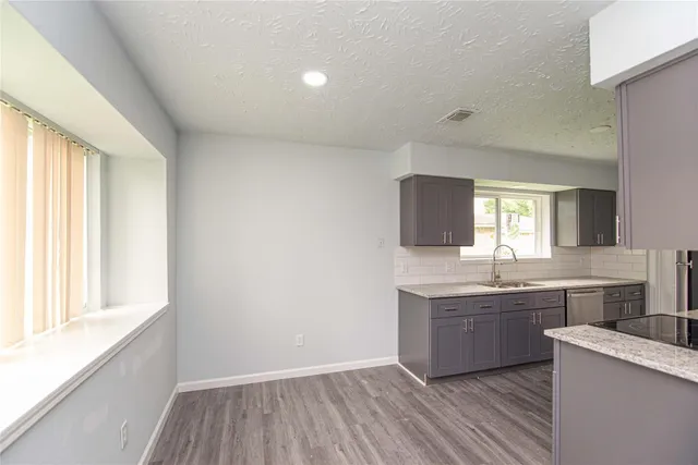 a view of a kitchen with sink cabinets and wooden floor