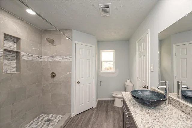 a bathroom with a granite countertop tub a sink and a shower