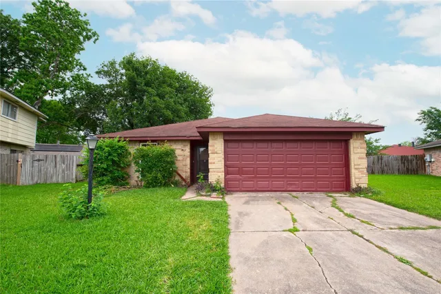 a view of a house with a small yard and a large tree