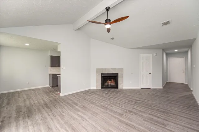 a view of empty room with wooden floor and fireplace