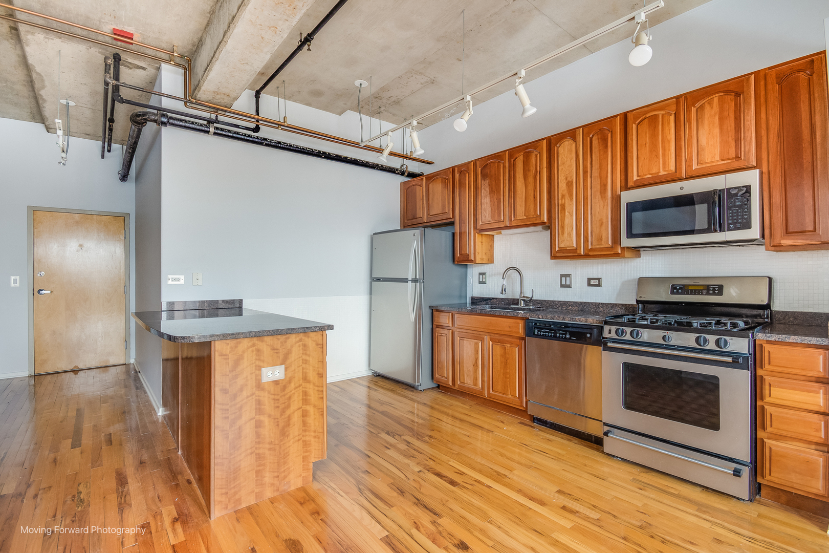 6 South Laflin Street, Unit 923 Chicago, IL 60607 - Photo 3 of 19 a kitchen with stainless steel appliances granite countertop a stove a refrigerator and a microwave