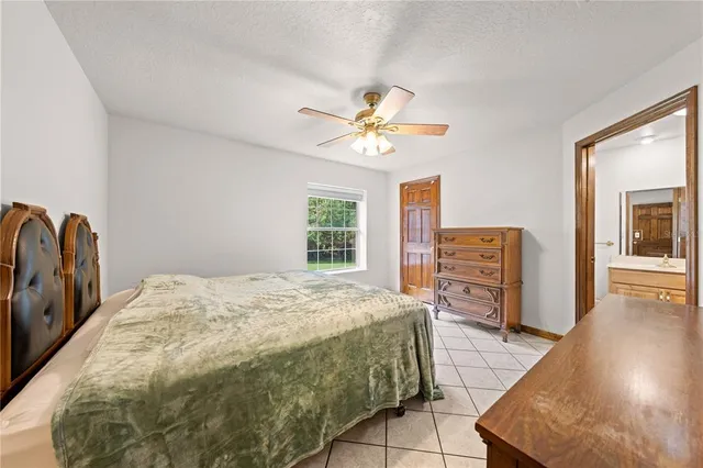 a spacious bedroom with a bed and a chandelier