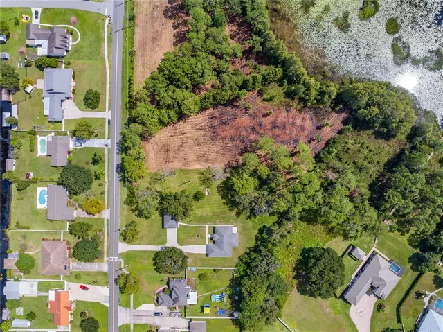 an aerial view of a residential houses with yard