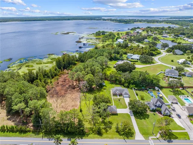 an aerial view of a house with a yard and lake view