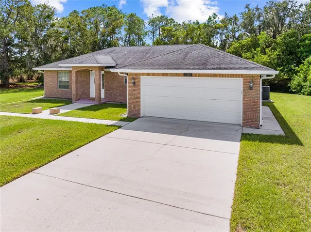 a aerial view of a house with a yard and a fountain