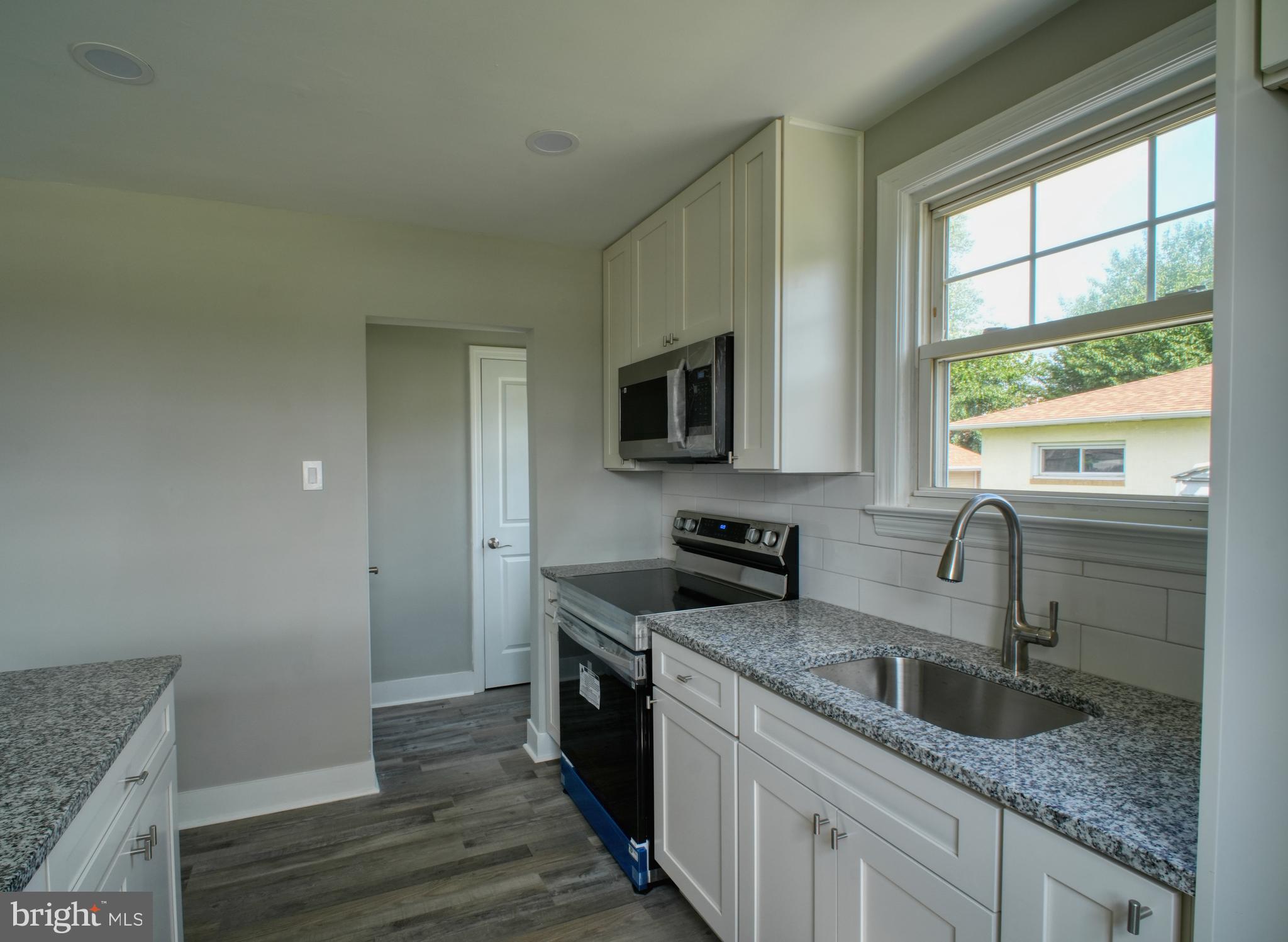 3220 Byberry Road Philadelphia, PA 19154 - Photo 19 of 31 a kitchen with granite countertop stainless steel appliances a sink window and cabinets